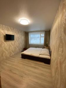 ペトロパブロフスク・カムチャツキーにあるWELCOME HOME Aparts & Tours 1233 Бесконтактное заселениеのベッドルーム1室(ベッド1台、壁にテレビ付)