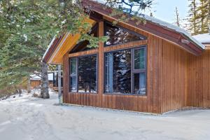 a cabin with a large window in the snow at Canmore Cabin by Canadian Rockies Vacation Rentals in Canmore