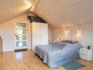 1 dormitorio con 1 cama en una habitación con paredes de madera en Holiday home Hals C, en Hals
