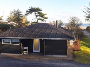 a small house with a black roof and a door at Luxury Beach House with Spa - By Traum Ferienwohnungen in Hals