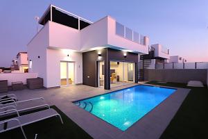 a house with a swimming pool in front of it at New villa with rooftop terrace and pool in Daya Nueva