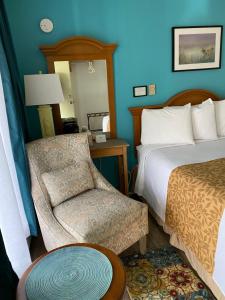a hotel room with a bed and a chair at La Kris Inn in Bandon