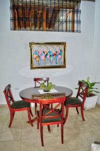 a table with two chairs and a painting on the wall at Casa Serrano - Calle Real 5 in Mompós