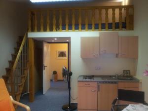 a kitchen with a staircase and a room with a sink at Landhaus Wachendorf in Bruchhausen-Vilsen