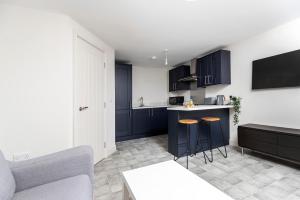 a kitchen with black cabinets and bar stools at Avery House 1 - One Bedroom with Outdoor Terrace in Darlington