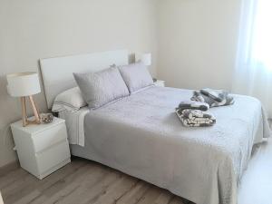 - une chambre blanche avec un lit et une lampe dans l'établissement La Casa de Maricruz, à Cangas de Onís