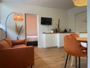 een woonkamer met een bank en een tafel met stoelen bij Northgo apartment in Noordwijk