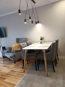 a dining room with a white table and chairs at Family & Business Elegant Apartments Rynek Centrum Downtown - 2 Bedroom, Balcony, Parking in Kielce