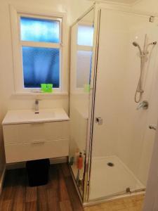 baño con lavabo y ducha con ventana en Homestay Family room, near the city center en Christchurch