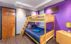 a bunk bed in a room with purple walls at newcastle spacious city centre apartments in Newcastle upon Tyne
