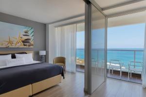 a bedroom with a bed and a view of the ocean at Resort Hadera by Jacob Hotels in H̱adera