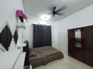 um quarto com uma cama e uma ventoinha de tecto em Licuala Homestay Bukit Keluang em Kampung Raja