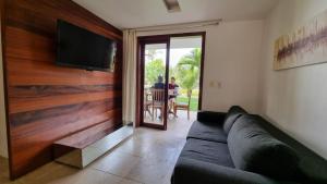 a living room with a couch and a flat screen tv at Apt no Taiba Beach Resort in Taíba