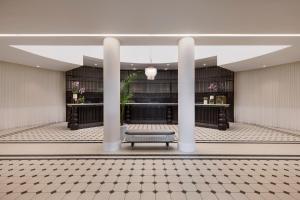 a lobby with a bench in the middle of a building at Resort Hadera by Jacob Hotels in H̱adera