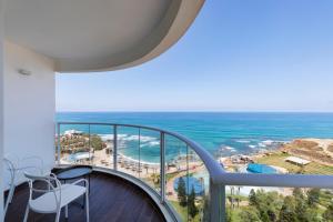 a balcony with a view of the ocean at Resort Hadera by Jacob Hotels in H̱adera