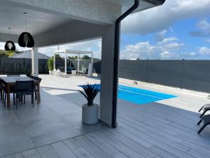 Un patio con mesa y sillas y una piscina. en VILLA LE LYS, en Saint-François