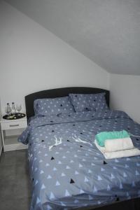 a bedroom with a bed with a blue comforter at Šepački Most, Banja Koviljača, Loznica in Loznica