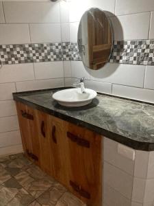 W łazience znajduje się umywalka i lustro. w obiekcie Pura Vida Vegana w mieście Cahuita