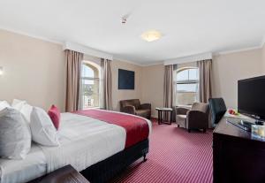 um quarto de hotel com uma cama e uma televisão em Hotel Grand Chancellor Launceston em Launceston