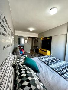 1 dormitorio con 1 cama grande y TV de pantalla plana en BC Beach Art Studio, en Balneário Camboriú