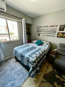 1 dormitorio con cama, ventana y sofá en BC Beach Art Studio, en Balneário Camboriú