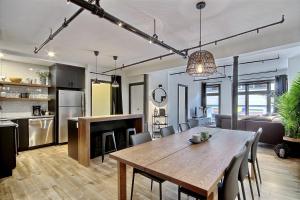 a kitchen and dining room with a wooden table in a room at Le Gentleman // Downtown spacious condo in Quebec City