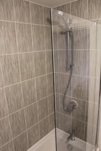 a shower with a glass door in a bathroom at Penelope Maison - London in 50 Mins, Free Parking, 1 BDRM Home in Peterborough