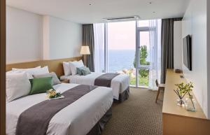 Postel nebo postele na pokoji v ubytování Naksan Beach Hotel