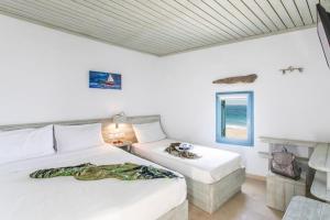 a bedroom with two beds and a window at Meltemi apartment by opus in Agios Stefanos