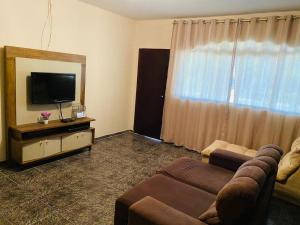 un salon avec un canapé et une télévision dans l'établissement Chácara Cateto, à Socorro