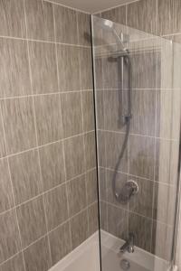 y baño con ducha y puerta de cristal. en Beautiful 1-Bed House in Peterborough, en Peterborough