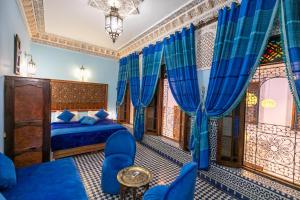 sypialnia z niebieskim łóżkiem i niebieskimi zasłonami w obiekcie Dar Fes Tresor w Fezie
