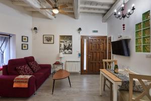 a living room with a red couch and a table at Casa Rural Planeta Vera in Jarandilla de la Vera