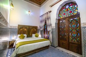 sypialnia z łóżkiem i witrażem w obiekcie Dar Fes Tresor w Fezie