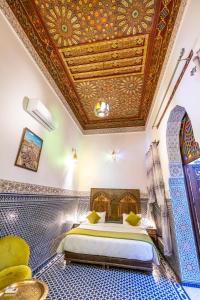 een slaapkamer met een bed en een plafond met tegels bij Dar Fes Tresor in Fès