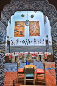 una habitación con mesas y sillas y un cuadro en la pared en Dar Fes Tresor en Fez