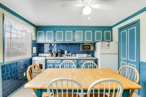 a blue kitchen with a wooden table and chairs at Royal Palm Court B5 in Ocean City