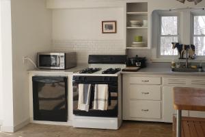 a kitchen with a stove and a microwave at Vermont Farm in Proctorsville