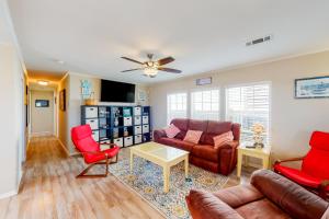 a living room with a couch and red chairs at The Wright House in Port Bolivar