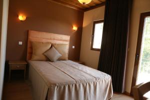 een slaapkamer met een bed en een raam bij Casa do Olival in Macedo de Cavaleiros