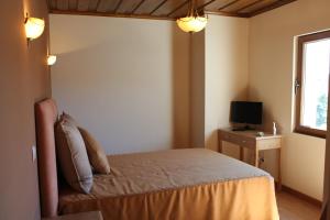 a bedroom with a bed and a desk with a television at Casa do Olival in Macedo de Cavaleiros