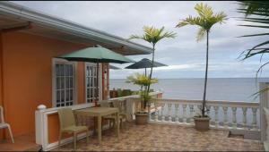 a balcony with a table and chairs and the ocean at Serdena Homestay Fronting Cuatro Islas in Hindang