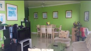 a living room with a table and a green wall at Serdena Homestay Fronting Cuatro Islas in Hindang