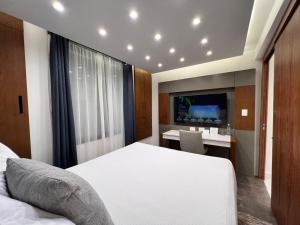 Dormitorio con cama, escritorio y TV en Seven Boutique Apartments Cancún en Cancún