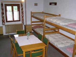 a room with a table and chairs and bunk beds at Chata U Jakuba in Prášily