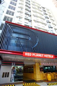 マニラにあるRed Planet Manila Malate Mabiniの赤い星のホテルの看板が貼られた建物