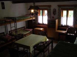 a room with bunk beds and a table and chairs at Chata U Jakuba in Prášily