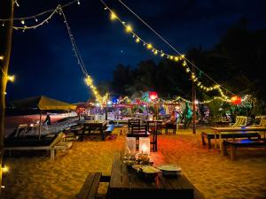 uma praia com mesas e luzes à noite em Mallika Guest House em Tangalle