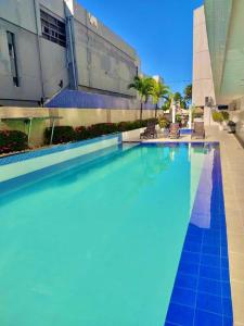 uma grande piscina em frente a um edifício em FLAT 134 - Imperial Flat Tambaú Nobile, beira-mar em João Pessoa em João Pessoa