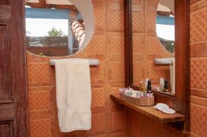 an orange bathroom with a mirror and a sink at La Juanita Hostel Barichara in Barichara